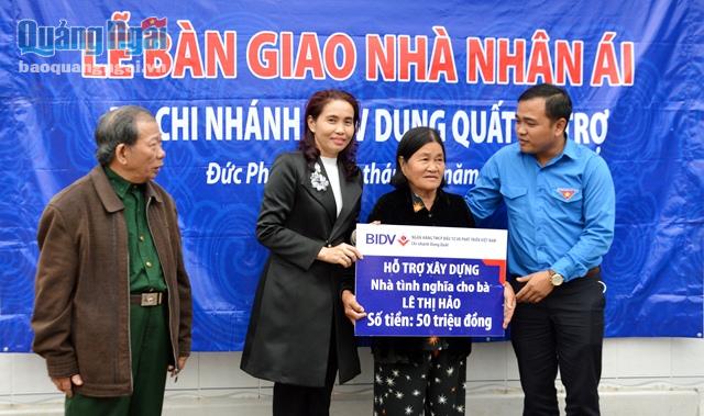 Đại diện Tỉnh đoàn và Ngân hàng BIDV chi nhánh Dung Quất trao bảng tượng trưng hỗ trợ tiền xây nhà cho gia đình bà Hảo
