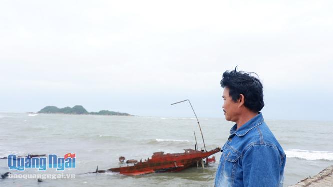 Ngư dân Nguyễn Thùy bên xác con tàu bị cháy.    