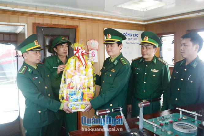 Chính trị viên Hải đội 2, đại úy Cao Tấn Vương (bìa trái) đến thăm, tặng quà động viên cán bộ, chiến sĩ tàu BP 09.11.01 trực làm nhiệm vụ xuyên Tết.