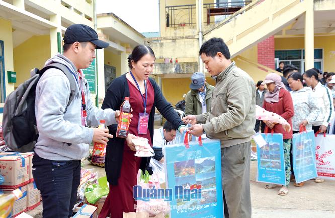 Thành viên nhóm FQng đang trao quà Tết cho người dân ở xã Long Môn (Minh Long). Đ.D