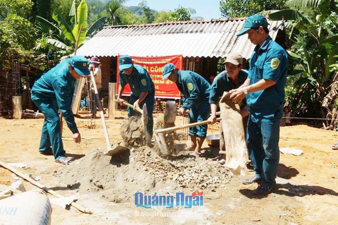 Dân quân huyện Trà Bồng tham gia ngày công xây dựng nhà ở cho hộ nghèo. Ảnh: Thành Hân