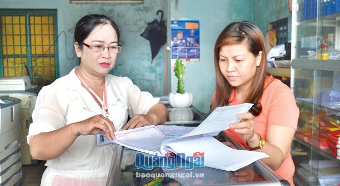 Cán bộ Chi cục Thuế Tư Nghĩa kiểm tra, hướng dẫn việc sử dụng hóa đơn của hộ kinh doanh tại thị trấn La Hà (Tư Nghĩa).