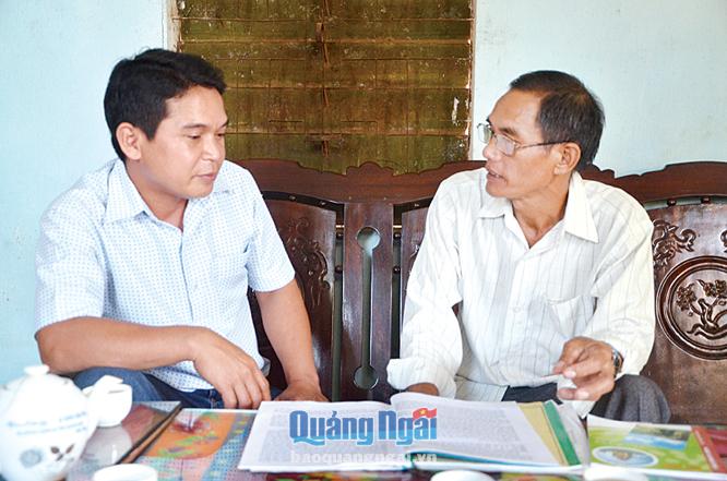 Ông Đinh Văn Tới (bên phải) trao đổi với cán bộ Hội CCB xã Sơn Hạ (Sơn Hà) về tình hình an ninh trật tự tại địa phương.