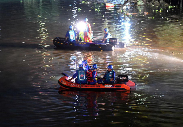Lực lượng cứu hộ tìm kiếm người mất tích trên sông Đào Hoa - Ảnh: Tân hoa xã