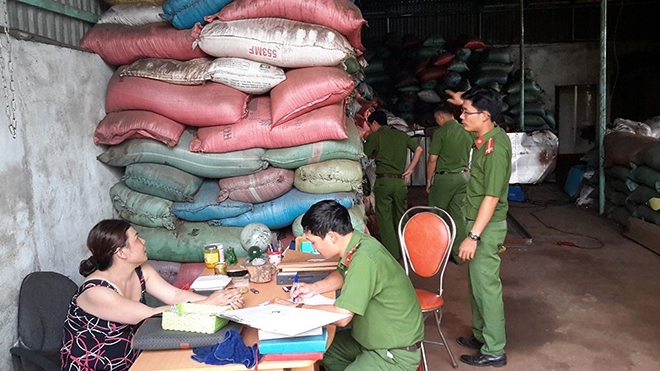 Lực lượng chức năng làm việc với chủ cơ sở sản xuất cà phê bẩn. Ảnh: TTXVN
