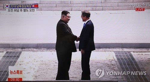Nhà lãnh đạo Triều Tiên Kim Jong-un (bên trái) bắt tay Tổng thống Hàn Quốc Moon Jae-in sau khi đi qua ranh giới hai nước sang phía Hàn Quốc