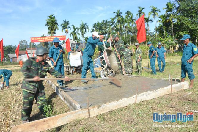 Cán bộ, chiến sĩ Ban CHQS huyện Nghĩa Hành giúp dân xã Hành Tín Tây làm đường bê tông.