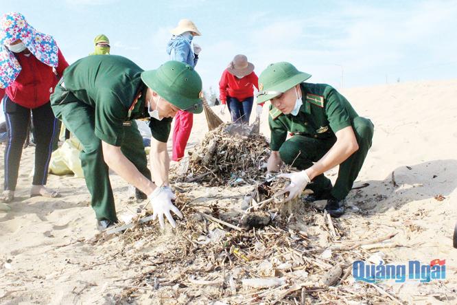 Cán bộ, chiến sĩ BĐBP thu gom rác thải ở bãi biển xã Nghĩa An (TP.Quảng Ngãi).