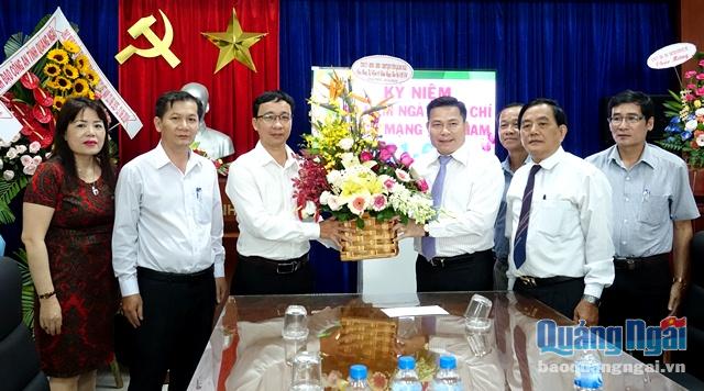 Phó Bí thư Tỉnh ủy Trần Văn Minh và các thành viên trong đoàn công tác tặng hoa chức mừng Báo Quảng Ngãi