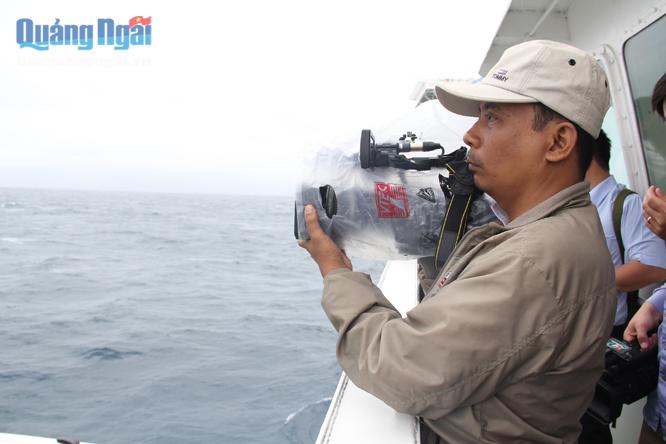 Phóng viên Thái Sambate của Đài PT –TH Trà Vinh phải dùng bao nilon để hạn chế phần nào hư hỏng cho máy quay phim trước những đợt sóng vươn cao, tạt lên cabin tàu do biển động.