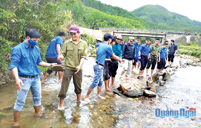 Đoàn viên thanh niên huyện Minh Long tham gia làm đập tạm cho người dân thôn Làng Ren, xã Long Môn.