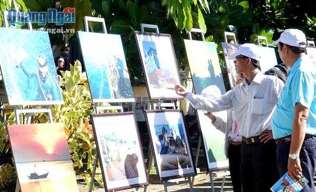 Đại biểu và du khách xem các hình ảnh ặc trưng văn hóa của cư dân đảo Lý Sơn, hoạt động khai thác biển và đấu tranh bảo vệ chủ quyền biển, đảo của cư dân đảo Lý Sơn