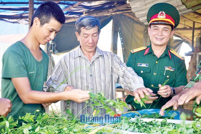  Ông Trần Phương Châu (giữa) giúp bộ phận hậu cần nhặt rau chuẩn bị bữa ăn cho bộ đội.