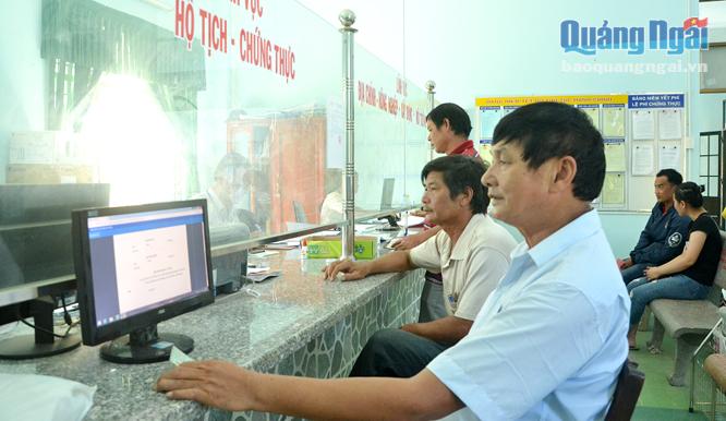 Cán bộ tại bộ phận một cửa ở xã Đức Phong (Mộ Đức) giải quyết thủ tục hành chính cho các tổ chức, công dân.