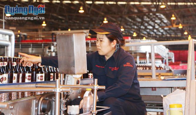 Công nhân làm việc trong dây chuyển sản xuất của Nhà máy Bia Sài Gòn - Quảng Ngãi.