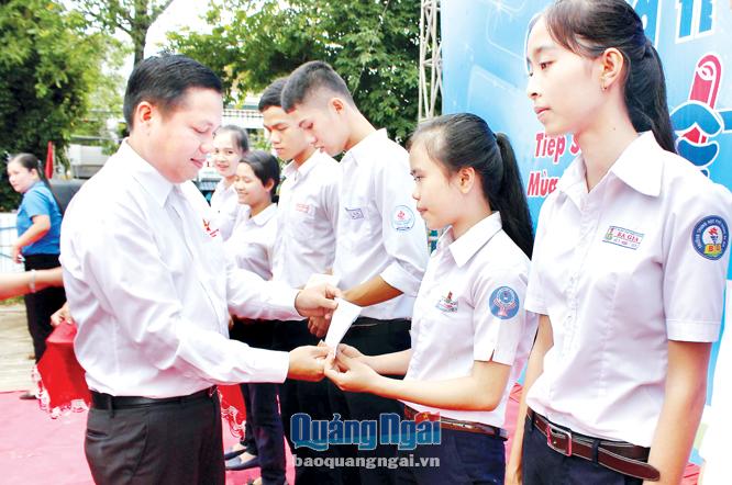Chủ tịch Hội doanh nhân trẻ tỉnh Vi Nhất Trường trao học bổng cho các em học sinh nghèo.