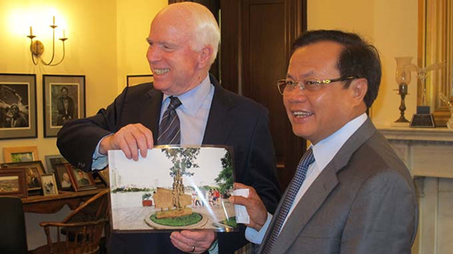 Thượng nghị sĩ John McCain nhận bức ảnh chụp bia chứng tích bên hồ Trúc Bạch từ Phạm Quang Nghị.             