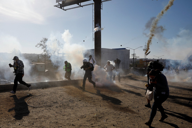 Người di cư tính vượt qua biên giới vào Mỹ ngày 25-11 tháo chạy vì hơi cay của cảnh sát - Ảnh: REUTERS