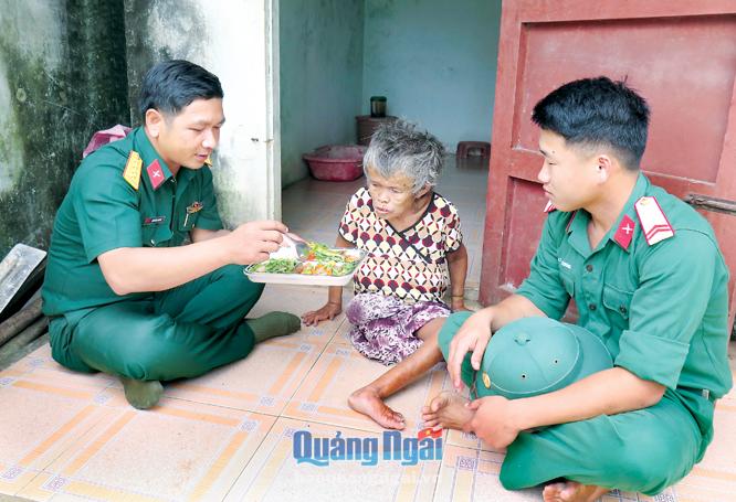 Cán bộ, chiến sĩ Ban Chỉ huy quân sự huyện Lý Sơn chăm lo bữa cơm trưa cho bà Dương Thị Nhượng. 