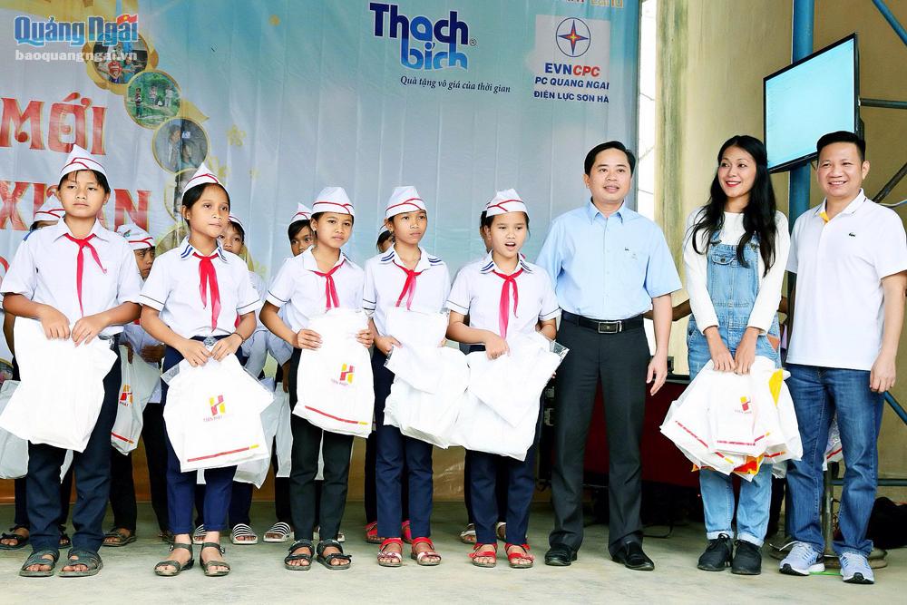Diễn viên Đinh Y Nhung và bác bĩ Võ Thành Trung (bên phải) trao tặng quà cho học sinh nghèo huyện Sơn Hà.