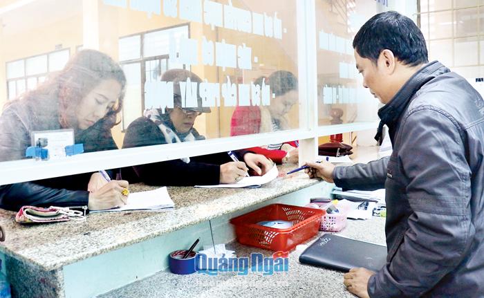 Cán bộ tư pháp phường Nghĩa Chánh hướng dẫn người dân làm thủ tục hành chính.
