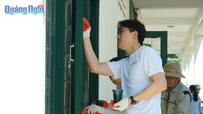 Lãnh đạo và công nhân viên Doosan Vina tham gia sơn cửa các phòng học.