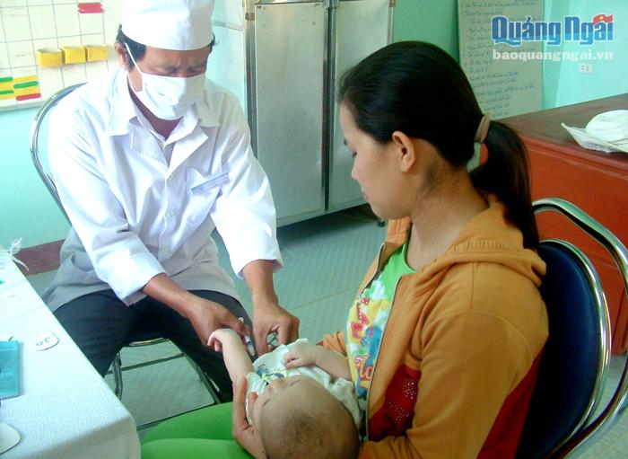 Cán bộ Trạm Y tế xã Nghĩa Dũng (TP.Quảng Ngãi) đang tiêm phòng cho trẻ.