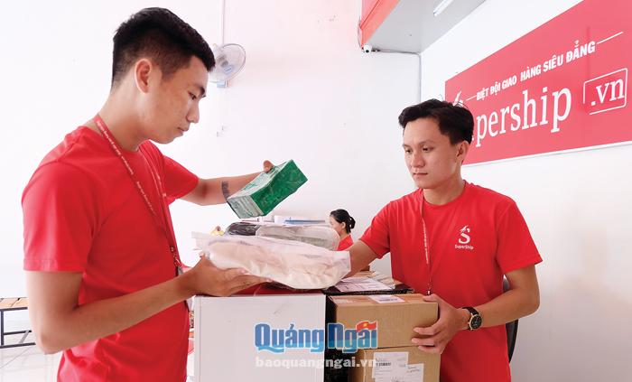  Anh Nguyễn Tấn Đạt (bên phải) cùng với nhân viên kiểm tra các đơn hàng.