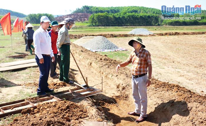  Phó Chủ tịch UBND huyện Bình Sơn Nguyễn Quang Trung (bên phải) động viên cán bộ và nhân dân xã Bình Tân làm kênh mương.