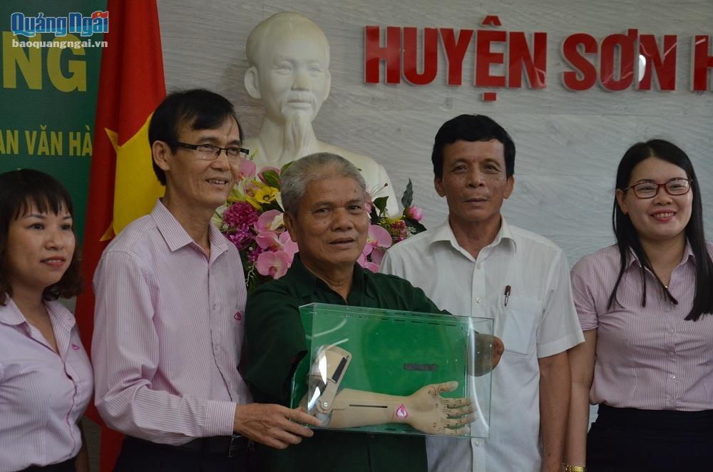 đại diện Ngân hàng Chính sách Xã hội tỉnh trao tặng cánh tay robot cho ông Phan Văn Hào