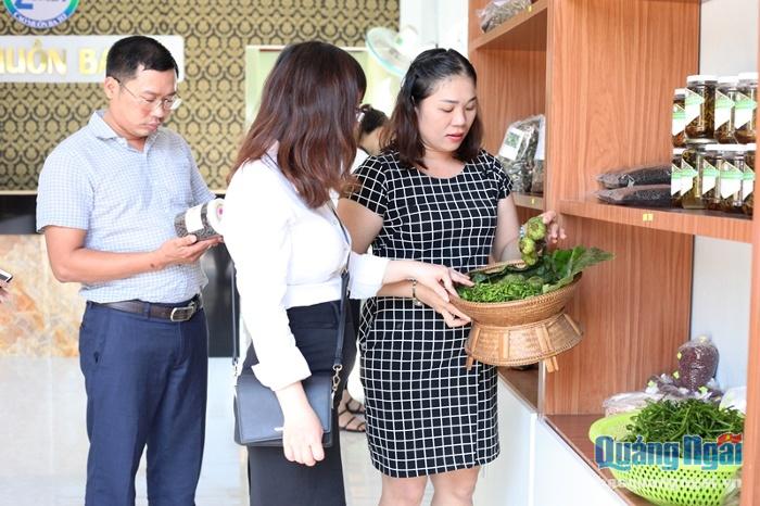 Chị Quyến tư vấn cho khách hàng về các đặc sản rừng được bày bán tại cửa hàng HTX Nông nghiệp Cao Muôn Ba Tơ.