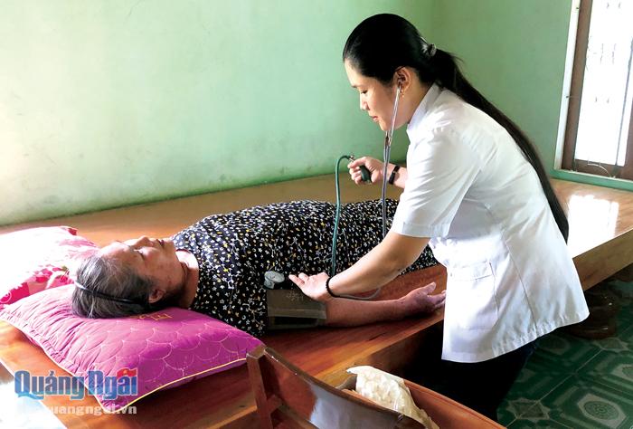 Nhân viên y tế huyện Minh Long chăm sóc sức khỏe tại nhà cho người cao tuổi già yếu.