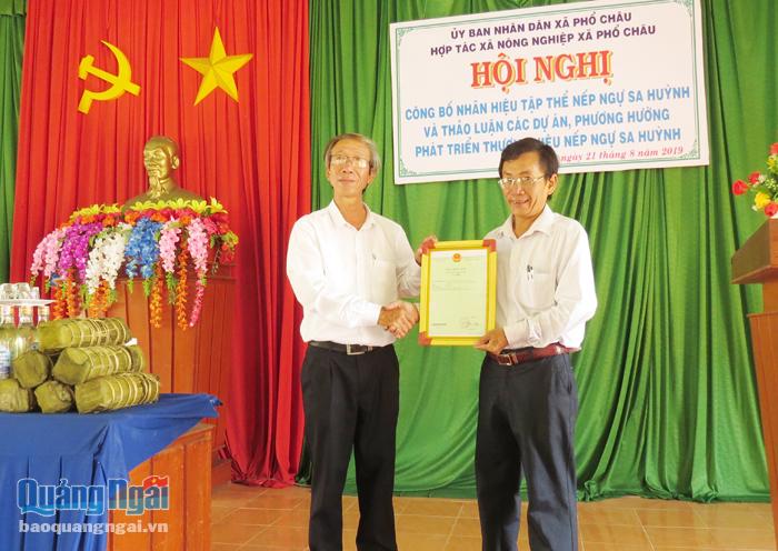Ông Sơn (bên phải) nhận giấy chứng nhận thương hiệu nếp ngự Sa Huỳnh