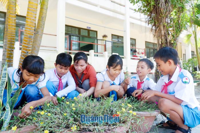 Mỗi ngày, giáo viên Trường Tiểu học và THCS Bình An (Bình Sơn) cùng học trò chăm sóc hoa, cây xanh trong sân trường.
