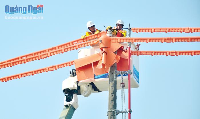  Nhân viên Công ty Điện lực Quảng Ngãi ứng dụng công nghệ hotline (không cắt điện khi sửa chữa) tại KCN Tịnh Phong.    
