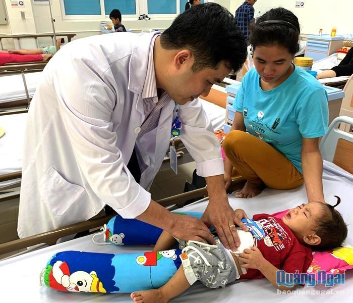 Cậu bé Đinh Văn Bi được bác sĩ Khoa Ngoại, Bệnh viện Sản-Nhi tỉnh kiểm tra sức khỏe sau ca phẫu thuật.