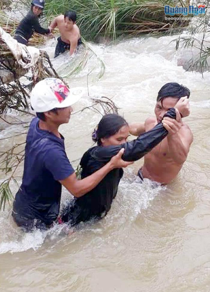 Các thành viên Ban Chỉ huy PCTT&TKCN xã Trà Tân (Trà Bồng) vượt dòng nước lũ cứu người. Ảnh: Nhị Phương 