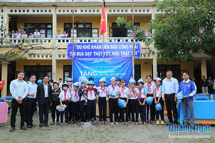 Đại diện Công ty CP thép Hòa Phát phối hợp trao mũ bảo hiểm cho học sinh