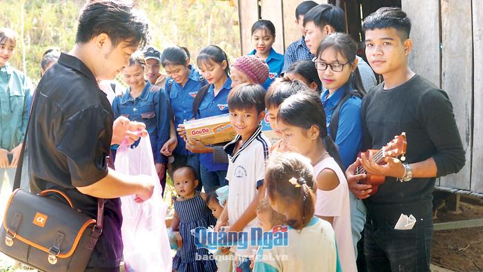 Đinh Quốc Tuấn tặng quà cho trẻ em Ca Dong ở huyện Sơn Tây trong một lần về thăm quê.