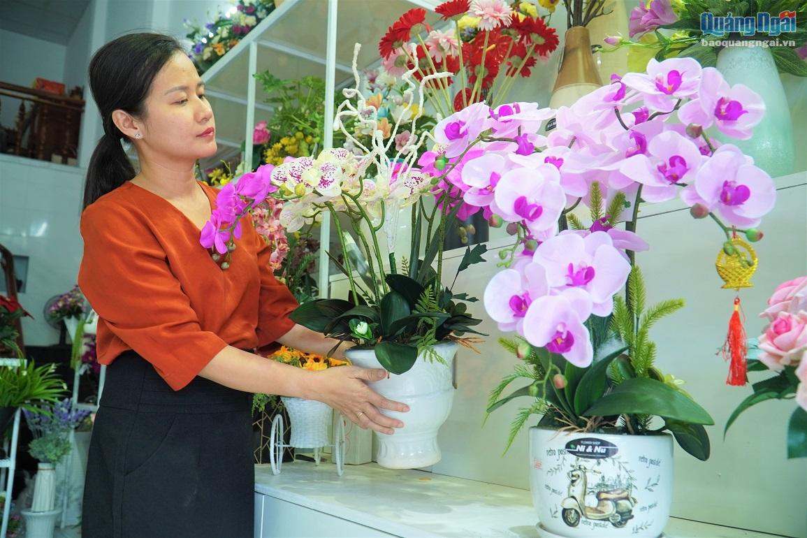 Chị Trịnh Thị Ý Nhi, chủ cửa hàng Ni & Nu đang bận rộn cắm cho khách hàng bình hoa lan.  