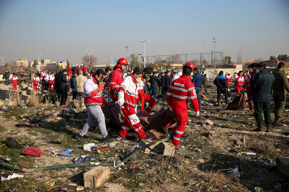 Các nhân viên cứu hộ di chuyển thi thể một hành khách trên chuyến bay xấu số rơi ở ngoại ô Tehran, Iran, ngày 8-1 - Ảnh: REUTERS