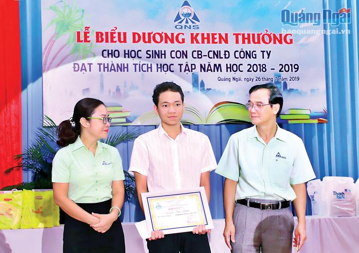 Chủ tịch Công đoàn Công ty CP Đường Quảng Ngãi Nguyễn Đình Quế (bên phải)  khen thưởng con em công ty học giỏi.