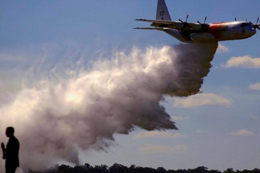 Chiếc máy bay không vận C-130 Hercules đang thả 15.000 lít lỏng chống cháy để dập lửa các đám cháy rừng. Ảnh: Reuters
