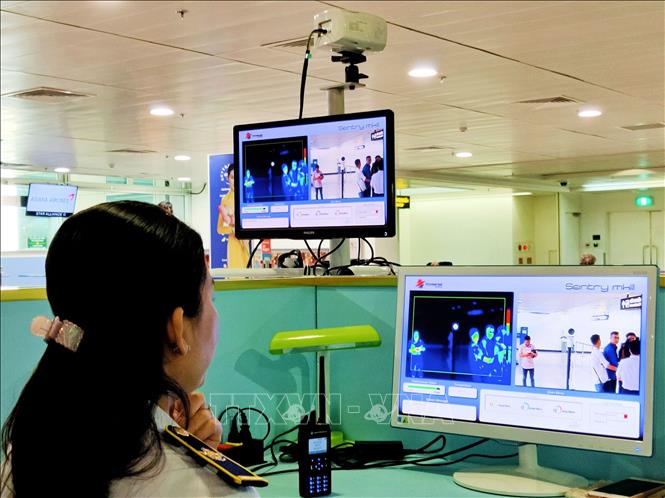 Nhân viên sân bay Tân Sơn Nhất kiểm tra màn hình hiển thị máy quét thân nhiệt đối với hành khách quốc tế đến Việt Nam. Ảnh minh họa: Đinh Hằng/TTXVN