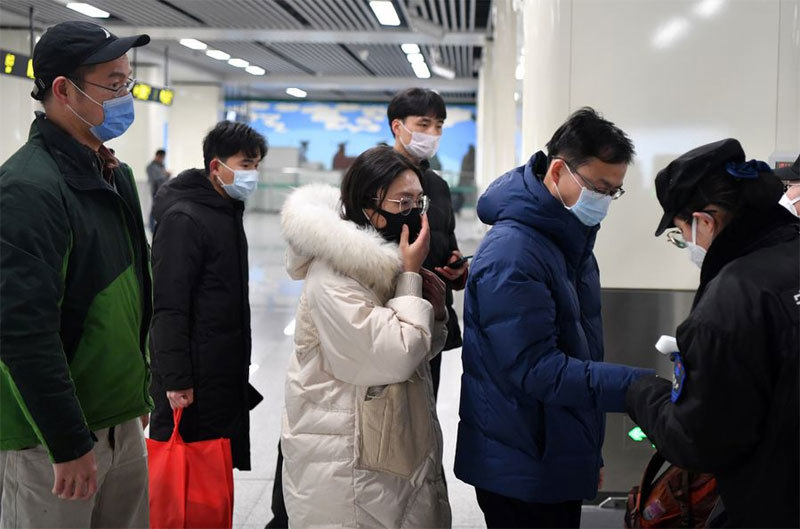 Hành khách xếp hàng kiểm tra nhiệt độ cơ thể tại một nhà ga ở Trịnh Châu, tỉnh Hà Nam, ngày 26/1/2020. (Ảnh: THX)