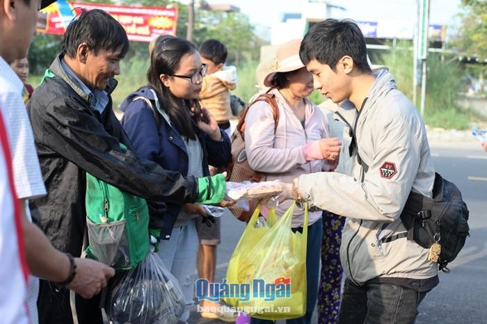Các tình nguyện viên hỗ trợ nước và đồ ăn sáng cho các thành viên trên chuyến xe sau khi về đến Quảng Ngãi.