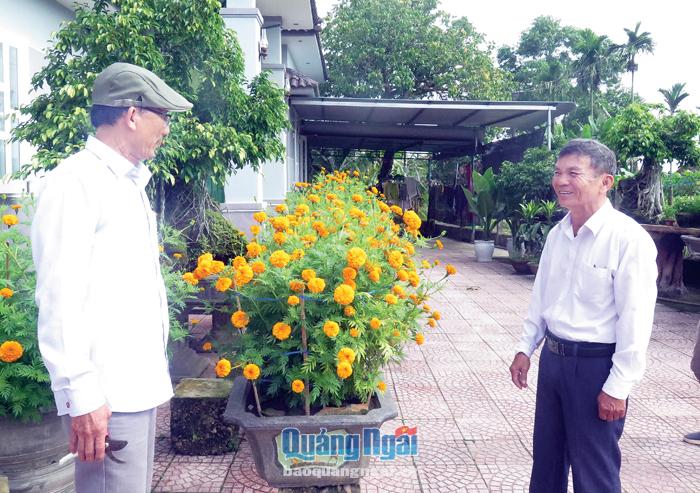 Ông Huỳnh Tư (bên phải) thăm hỏi người dân trong thôn trong ngày cận Tết. 