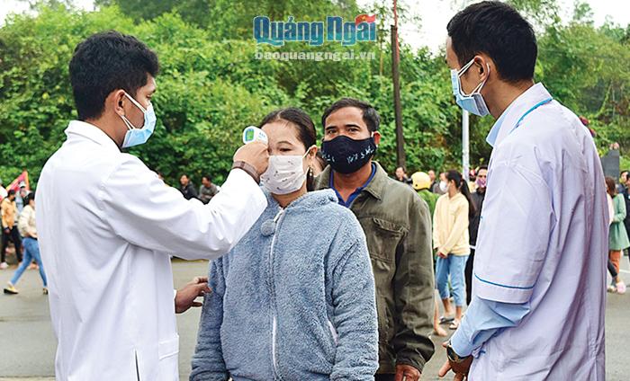 Nhân viên y tế huyện Minh Long kiểm tra thân nhiệt người dân đến tiễn thanh niên nhập ngũ tại Lễ giao, nhận quân ngày 11.2.
