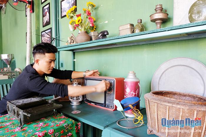 Anh Trần Việt Hùng bên cạnh những vật dụng mình sưu tầm được dùng để trưng bày trong quán cà phê.