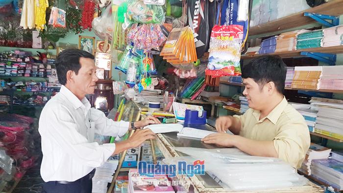 Cán bộ Chi cục Thuế khu vực Nghĩa Hành - Minh Long kiểm tra, hướng dẫn hộ kinh doanh sử dụng hóa đơn.